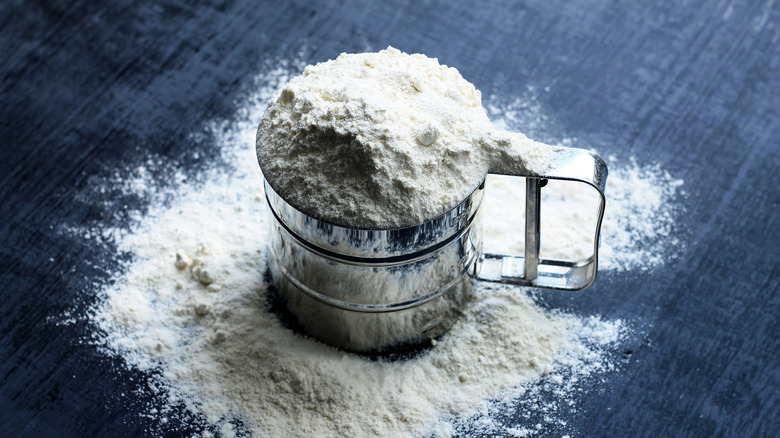sifter with flour on blue cloth