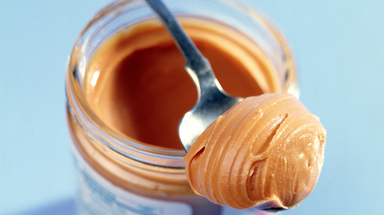 nut butter on spoon resting on jar