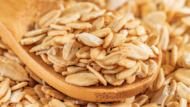 rolled oats on a wooden spoon closeup