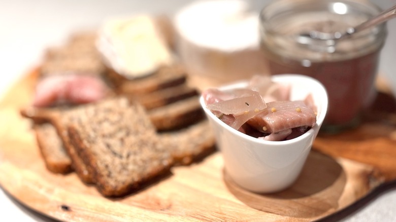 pickled herring with selection of breads, cheeses, and meats