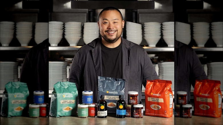 David Chang standing behind Momofuku products