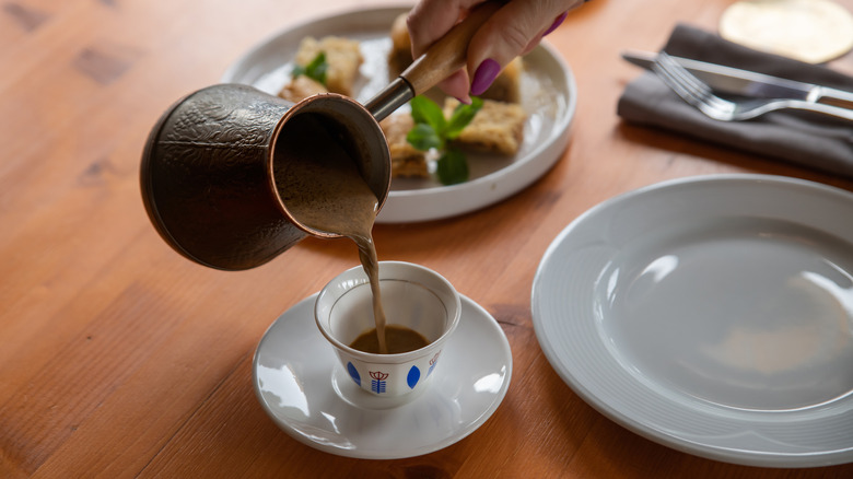 Arabic coffee pot pouring out a stream of coffee