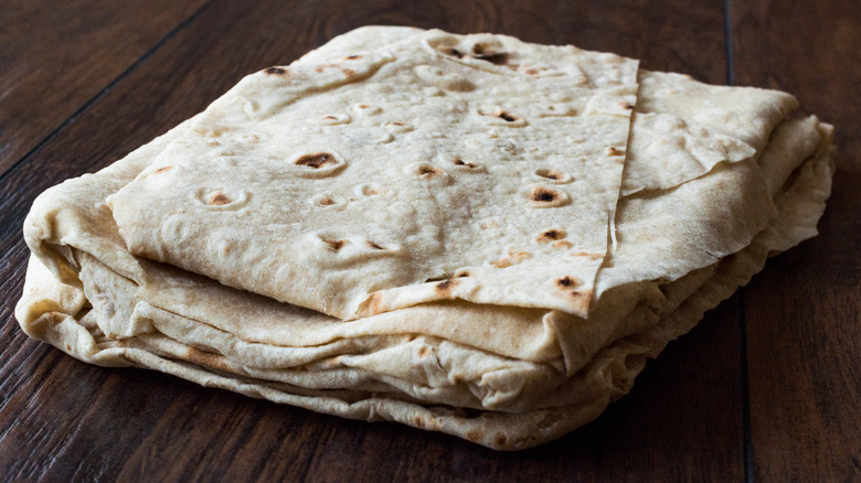 thin lavash bread folded on dark brown wooden table