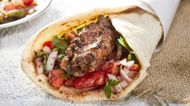 shawarma with meat, vegetables, and sauce on flatbread