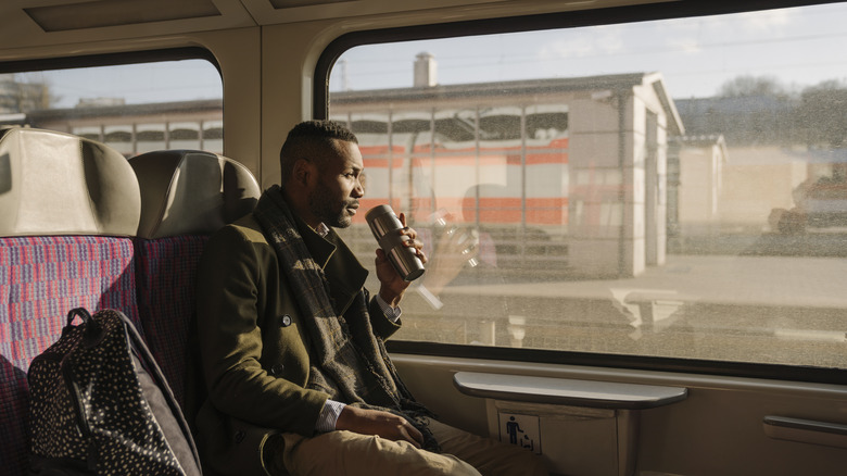 man drinking on train