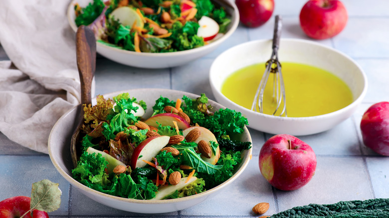 Two bright bowls of salad and a bowl of oil for dressing.