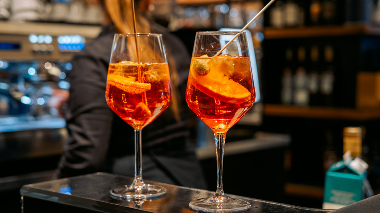 Two Aperol spritzes on a bar table