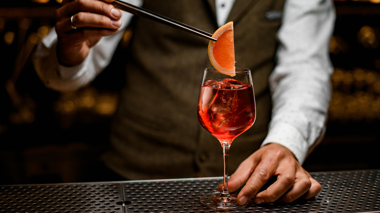 Bartender garnishing a spritz cocktail