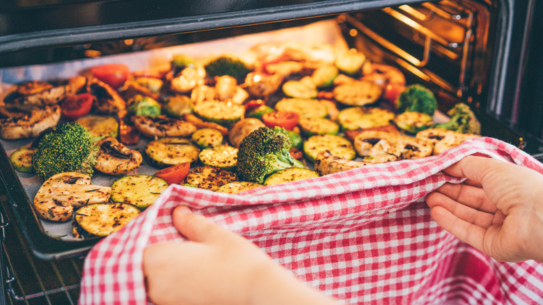 Person putting roasted vegetables in the oven