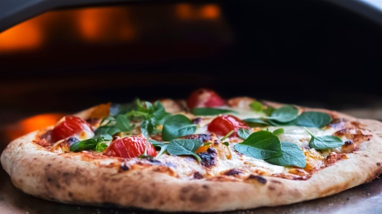 Pizza going into oven