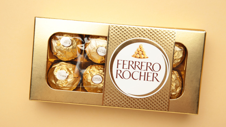 A package of Ferrero Rocher chocolates on a gold background