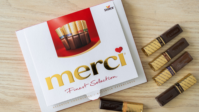 A box of Merci chocolates on a wooden table