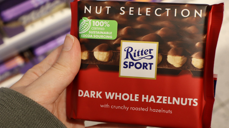 A person holding a Ritter Sport chocolate bar