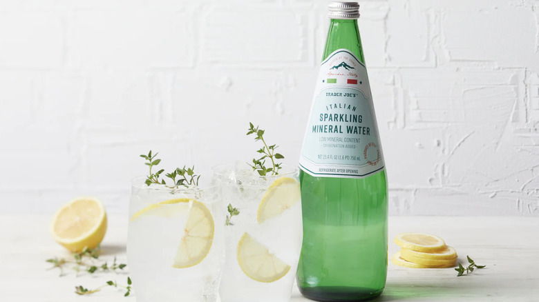 Italian Sparkling Mineral Water sitting next to glasses of Italian Sparkling Mineral Water with lemon
