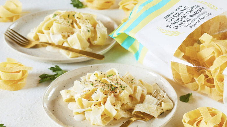 Trader Joe's Organic Papperdelle Pasta Nests package next to two dishes of Organic Papperdelle Pasta Nests