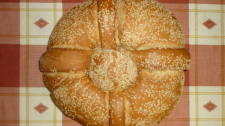 A loaf of Christopsomo bread sits on a tablecloth.