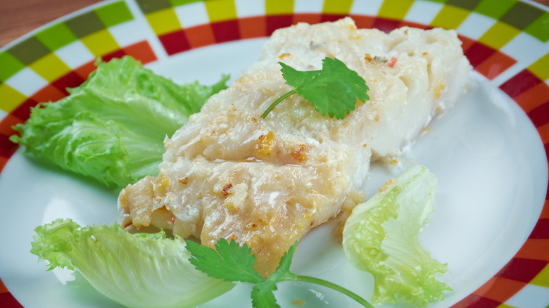 A plate of Lutefisk is paired with some lettuce.