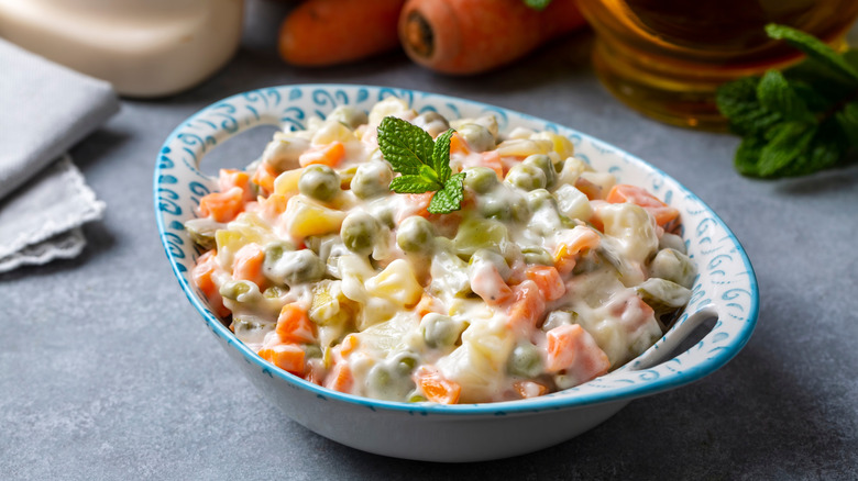 A bowl of Olivier salad from Russia sits on a table.