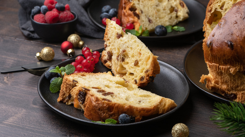 Slices of Italian panettone bread sit on a plate with berries.