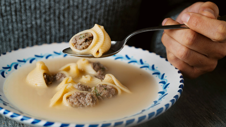 A person eats Sopa de galets from a bowl in Spain.