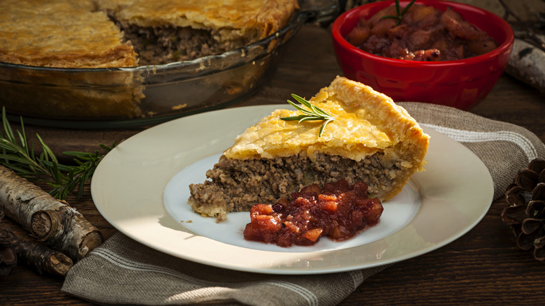 A slice of traditional Tourtiere pork pie sits on a plate.