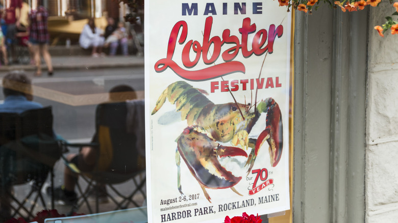 A poster for the Maine Lobster Festival displayed on the outside of a window