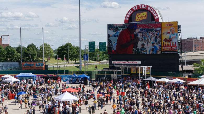 A crowd at the National Buffalo Wing Festival in front of a jumbotron display