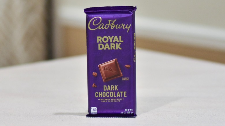 A bar of Cadbury dark chocolate on a white counter