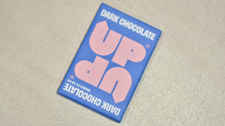 A bar of Up-Up dark chocolate on a white counter