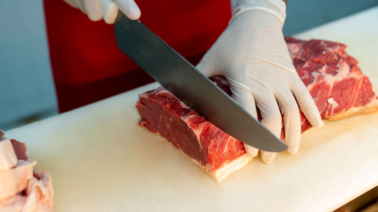 Butcher cutting beef