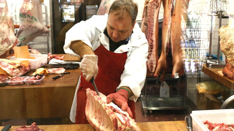 Whole Foods butcher cutting meat