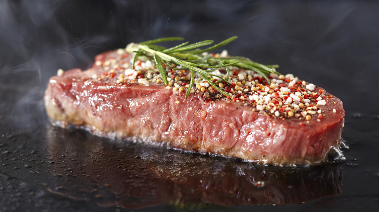 Raw steak searing with herbs