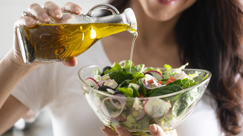 adding dressing to salad