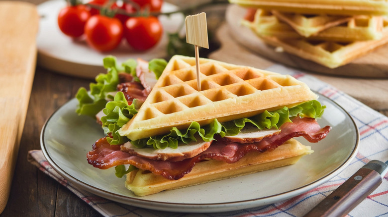 a waffle sandwich is filled with bacon and chicken