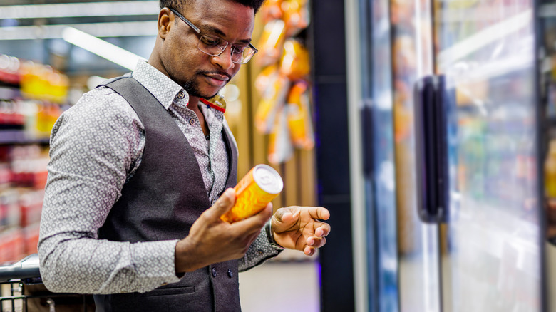 Person looking at the label on a can in a store