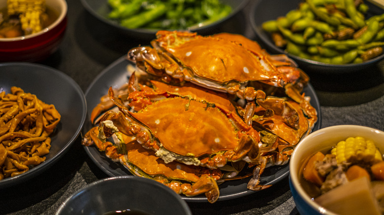 cooked crabs on a plate with various side dishes