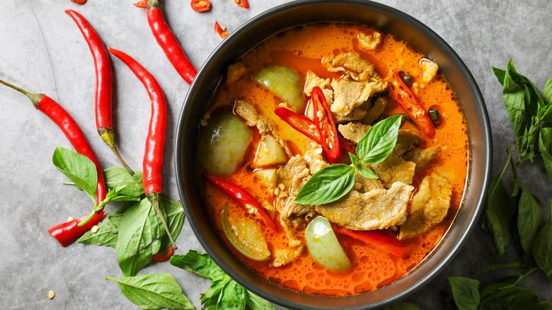 a bowl of curry with red chilis