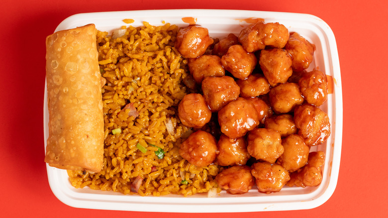 Plate of orange chicken with fried rice and eggroll