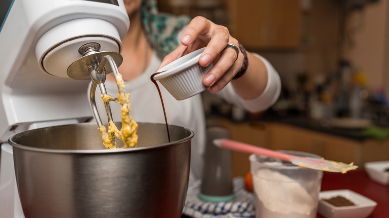 close up of adding extract to a mixing bowl