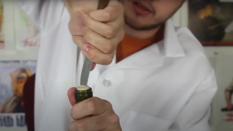 Man opening cork with knife.
