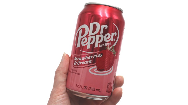 a hand holds a can of Strawberries and Cream Dr Pepper