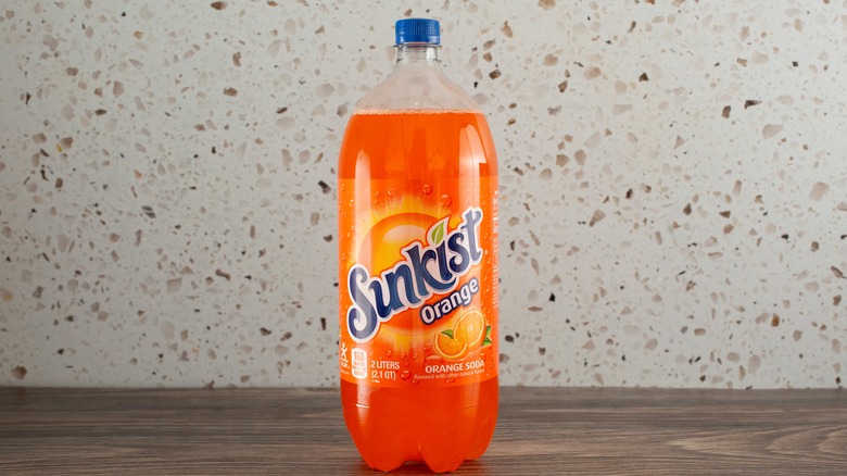 Sunkist orange soda on a table against speckled wall