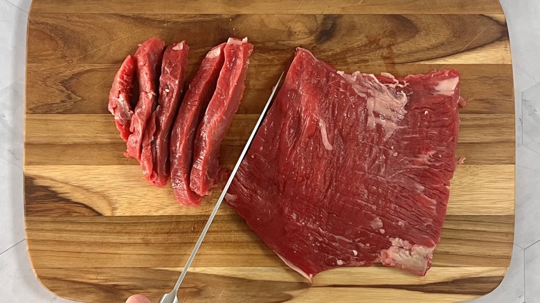 knife slicing raw steak