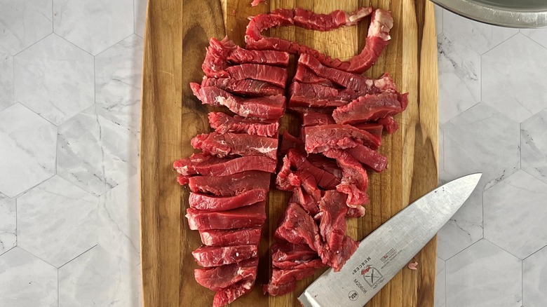 raw steak slices with knife