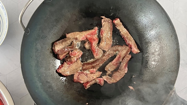beef strips cooking in wok