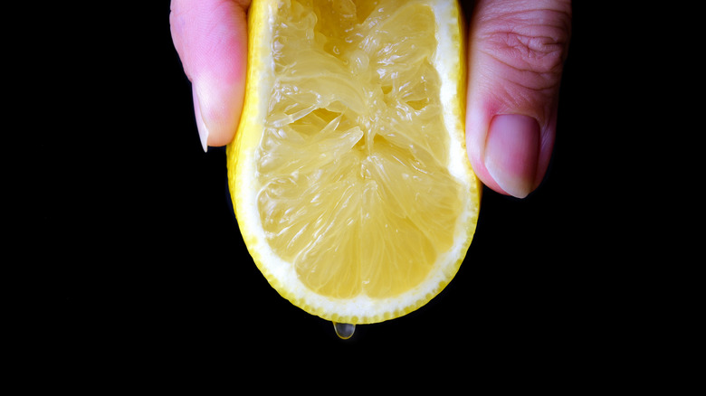 fingers squeezing a lemon