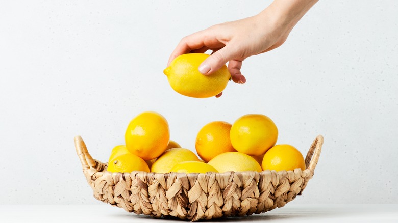 hand picking lemon from basket