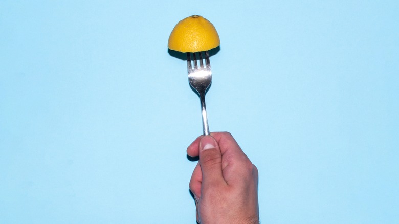 fork stabbing half a lemon