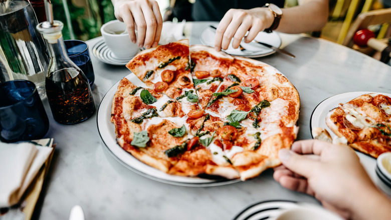 sharing pizza at restaurant