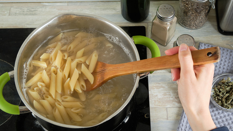 pasta noodles cooking in a metal pot